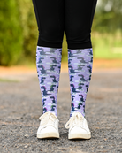 Dino-skate riding boot socks styled over breeches, lavender with dinosaurs skating on ice