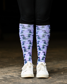 Dino-skate equestrian boot socks worn at the barn, lavender with dinosaurs skating on ice