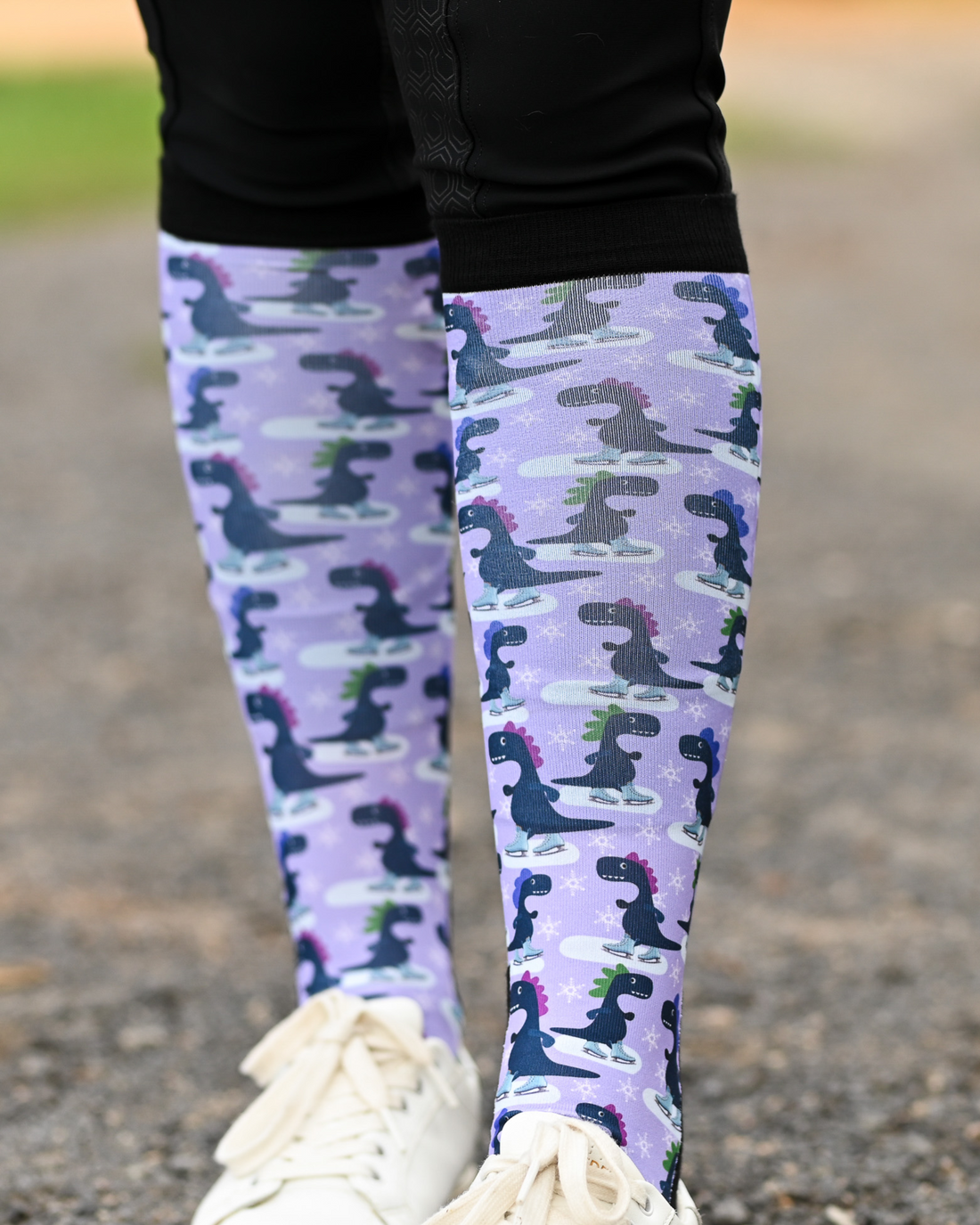 Close crop of the Dino-skate boot sock print, dinosaurs skating on ice on lavender