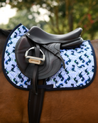 Side view of the Dino-skate saddle pad on a bay horse, tacked up with a brown jump saddle and stirrup down