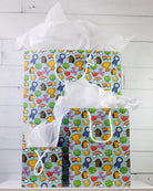 Full O' Luck gift bags in all three sizes on a white shelf, large behind with medium and small in front.