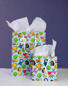 Full O' Luck gift bags in medium and small together on navy, both stuffed with white tissue paper.