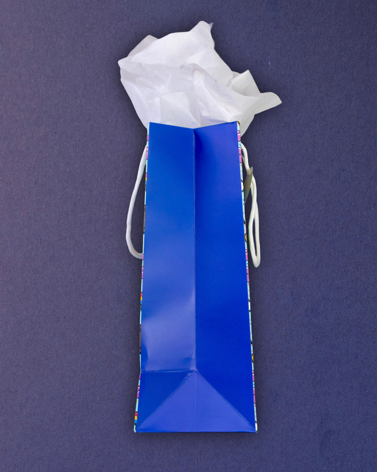 Full O' Luck medium gift bag laid on its side, royal blue gusset and folded base filling the frame.