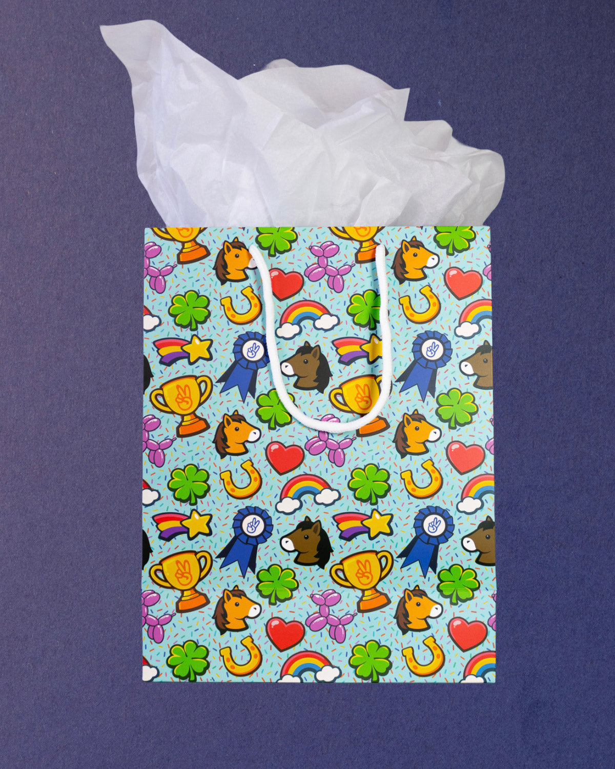 Full O' Luck medium gift bag square to camera, tissue paper spread wide above the lucky charm print.