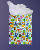 Full O' Luck medium gift bag square to camera, tissue paper spread wide above the lucky charm print.