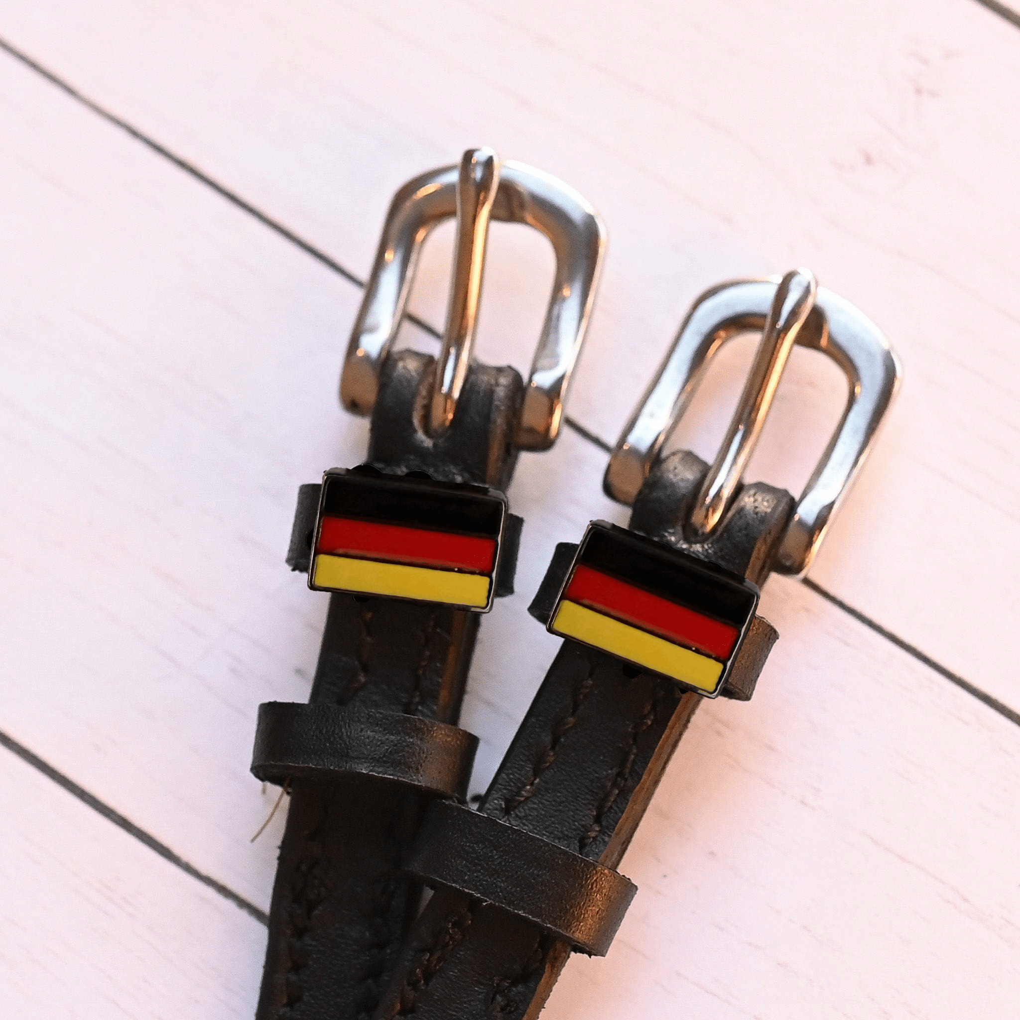 German flag-themed black leather spur straps with stainless steel buckle and custom charm