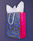 Hairy Styles medium gift bag angled right, blue front panel meeting the hot pink side gusset.