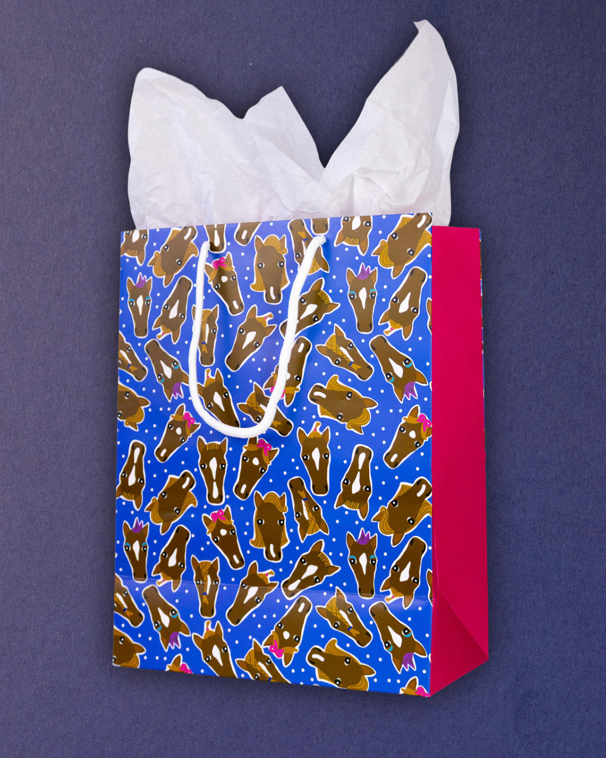 Hairy Styles medium gift bag at three-quarters, warm pink gusset and rope handles against navy.