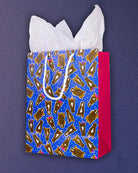 Hairy Styles medium gift bag at three-quarters, warm pink gusset and rope handles against navy.