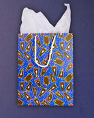 Hairy Styles medium gift bag flat from above, blue panel of pony faces with tissue paper fanned out.