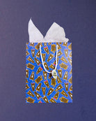 Hairy Styles medium gift bag standing front-on, tissue paper in two peaks above the blue pony print.