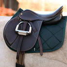 Hunter green saddle pad under brown equestrian saddle on horse back