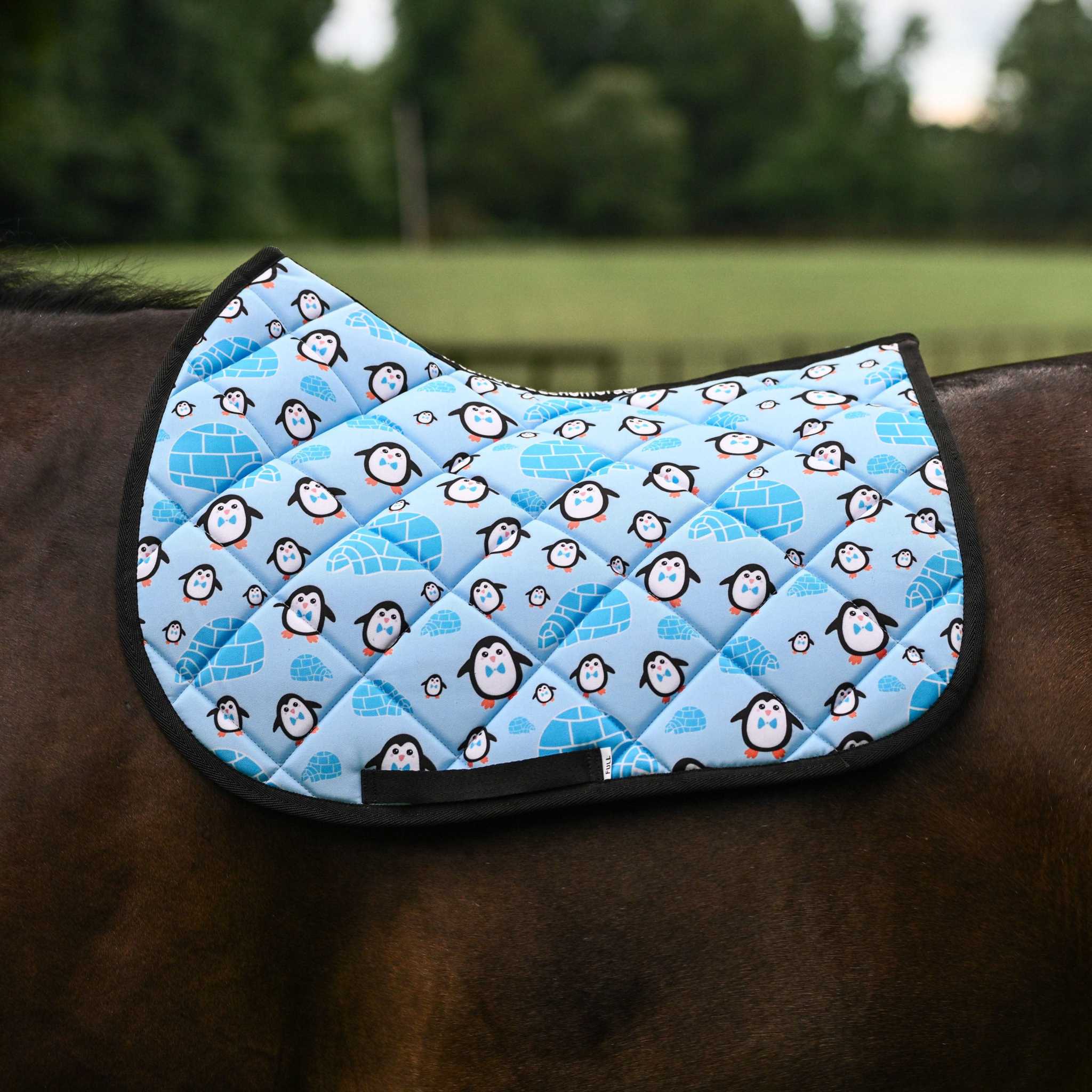 Igloo Crew Saddle Pad with playful penguin and igloo pattern on horse back