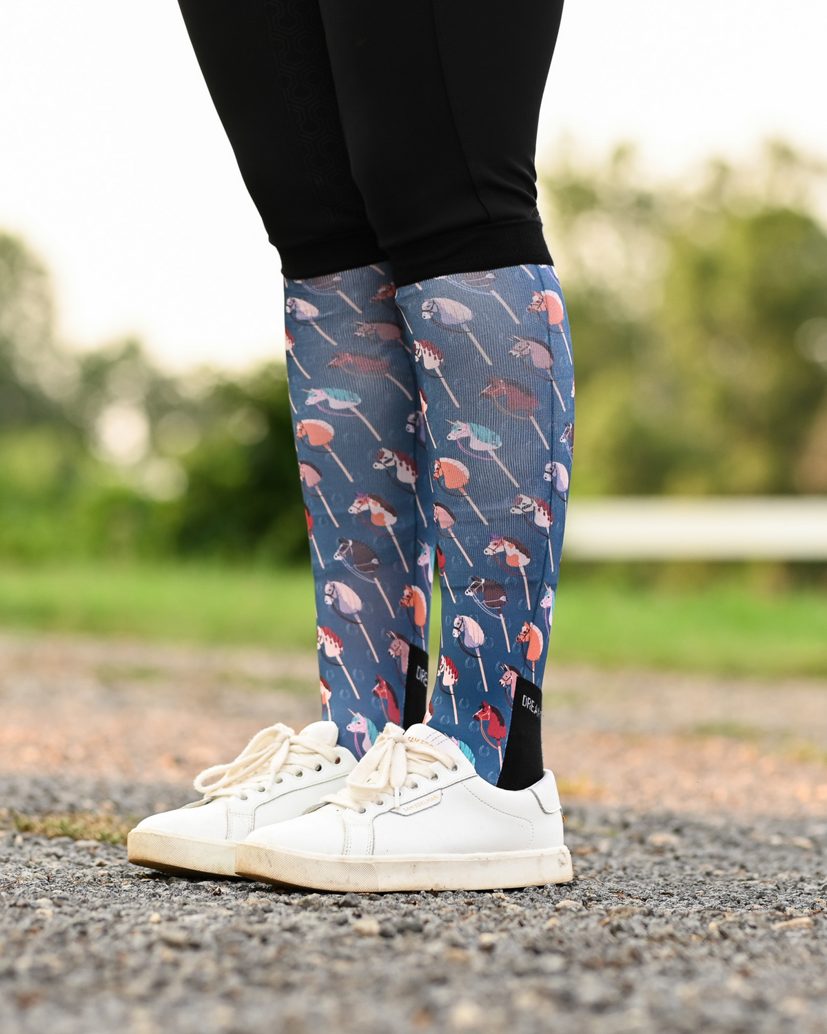 It's Not a Hobby riding boot socks styled over breeches, slate blue with hobby horses on wooden sticks