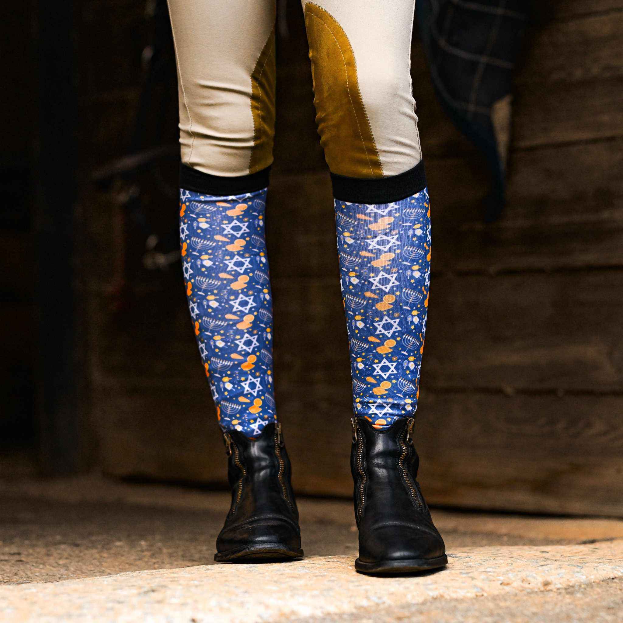Blue Keep Calm & Dreidel On riding socks with Hanukkah symbols worn with black riding boots