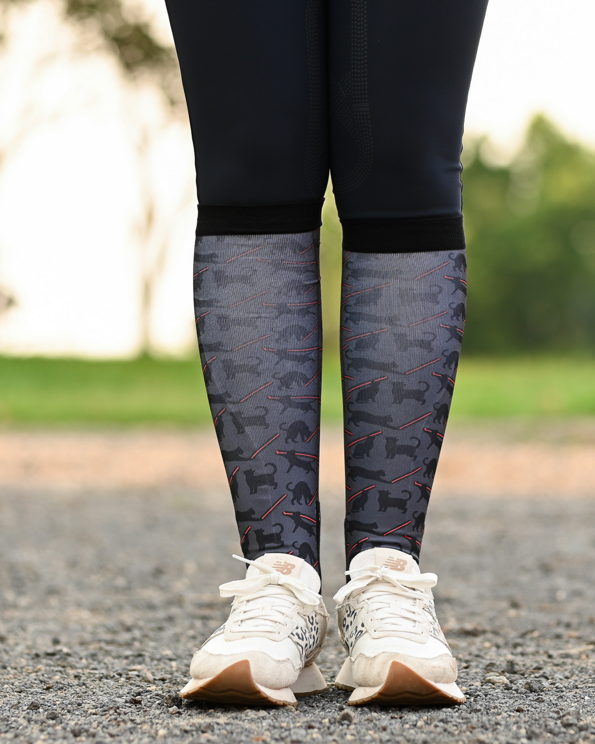 Laser Cats riding boot socks styled over breeches, charcoal with black cats firing red laser beams