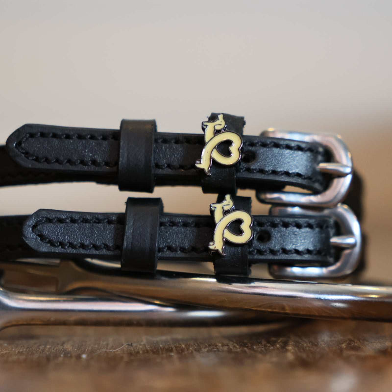 Black leather Long Dogs Spur Straps with stainless steel buckle and custom charm on peg wall display