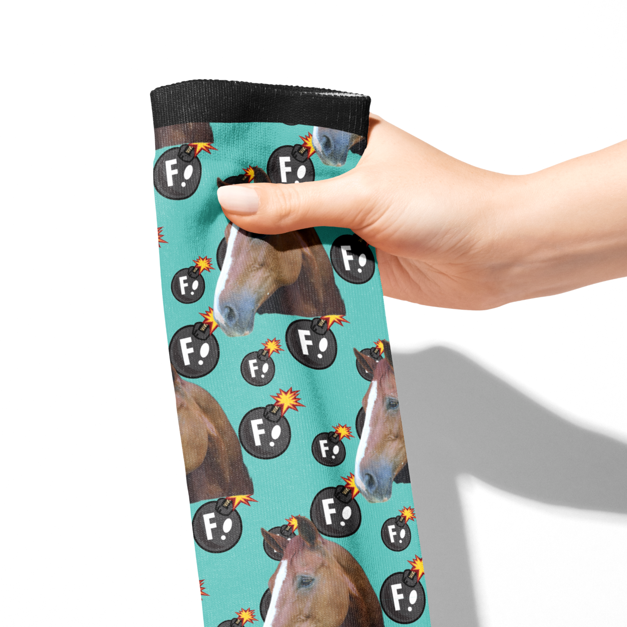 Custom Solo socks with horse and F Bombs pattern held in hand on turquoise background