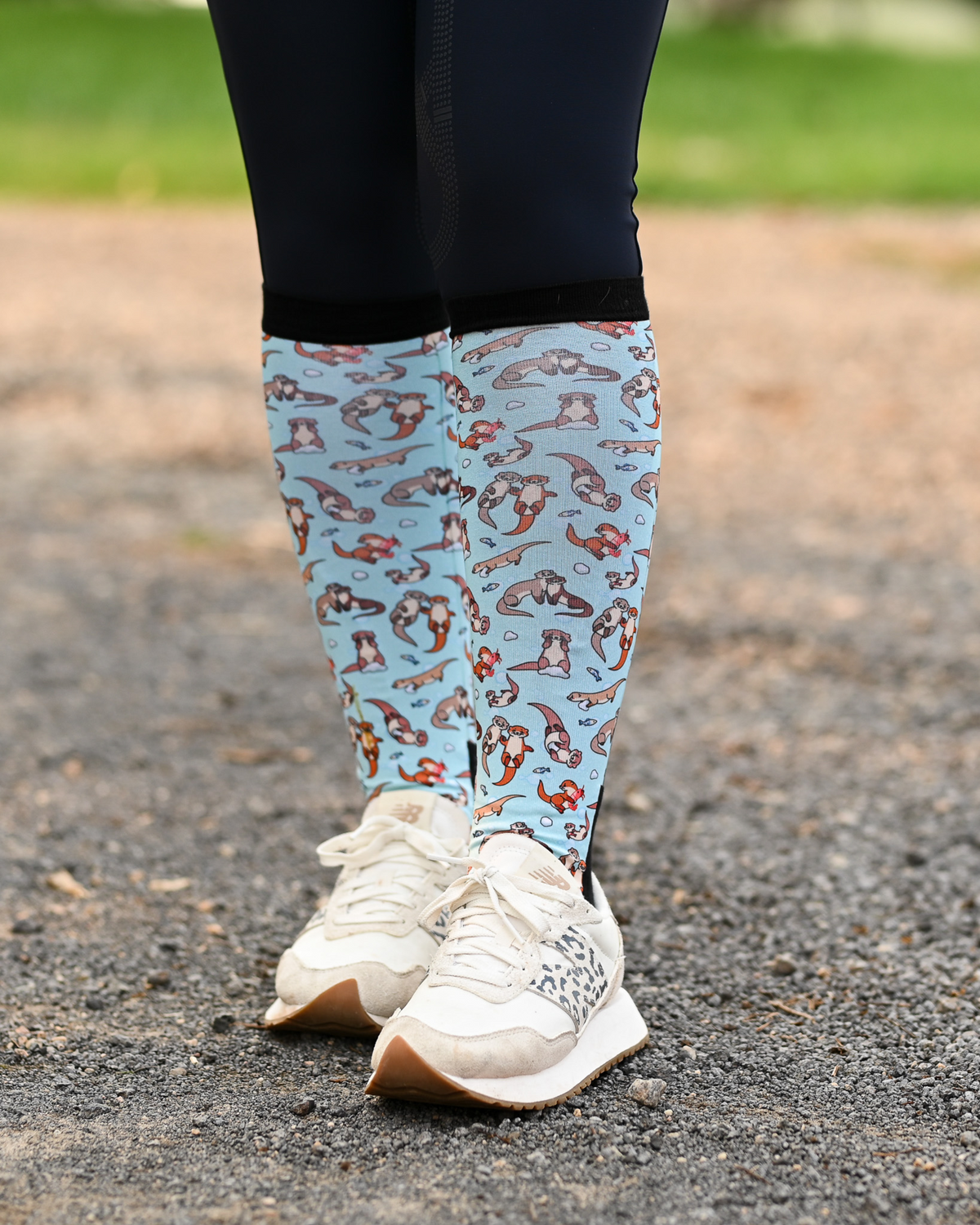 Otter-ly Adorable equestrian boot socks worn at the barn, pale blue with otters floating and holding hands