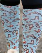 Close crop of the Otter-ly Adorable boot sock print, otters floating and holding hands on pale blue