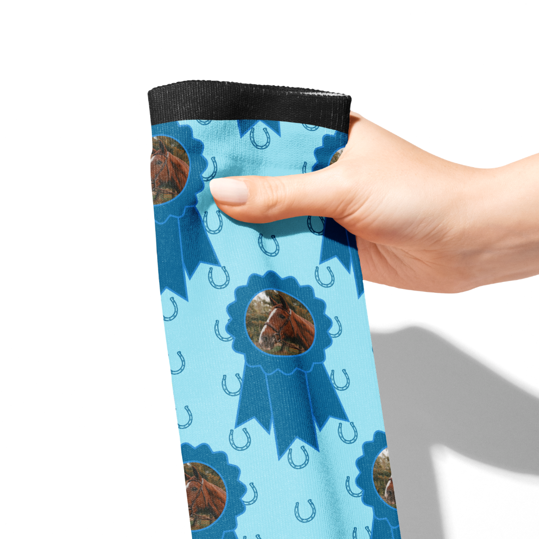 Hand holding custom blue ribbon socks with horse photo and blue horseshoe pattern