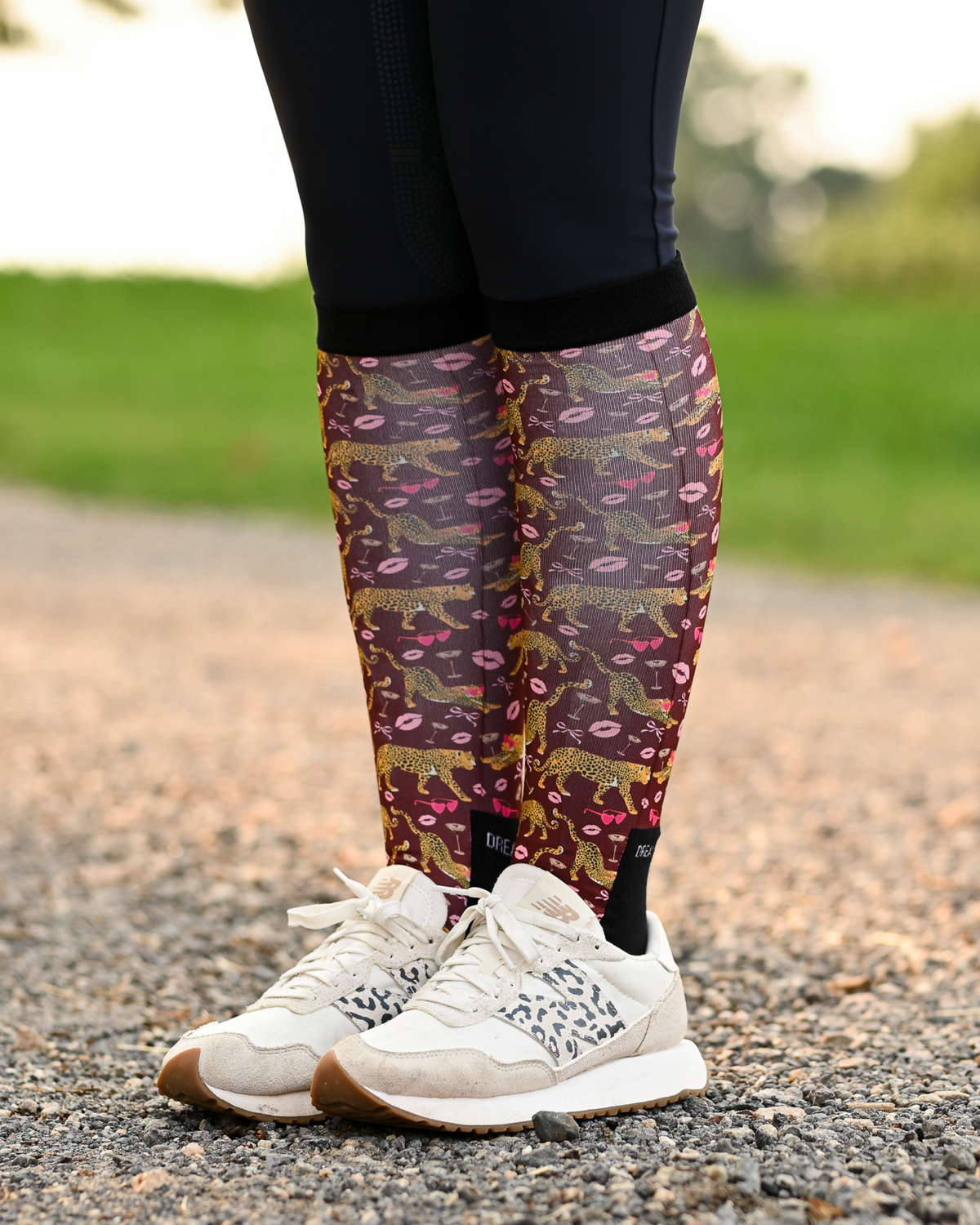 Ready to Play riding boot socks styled over breeches, burgundy with gold leopards, pink lips and bows