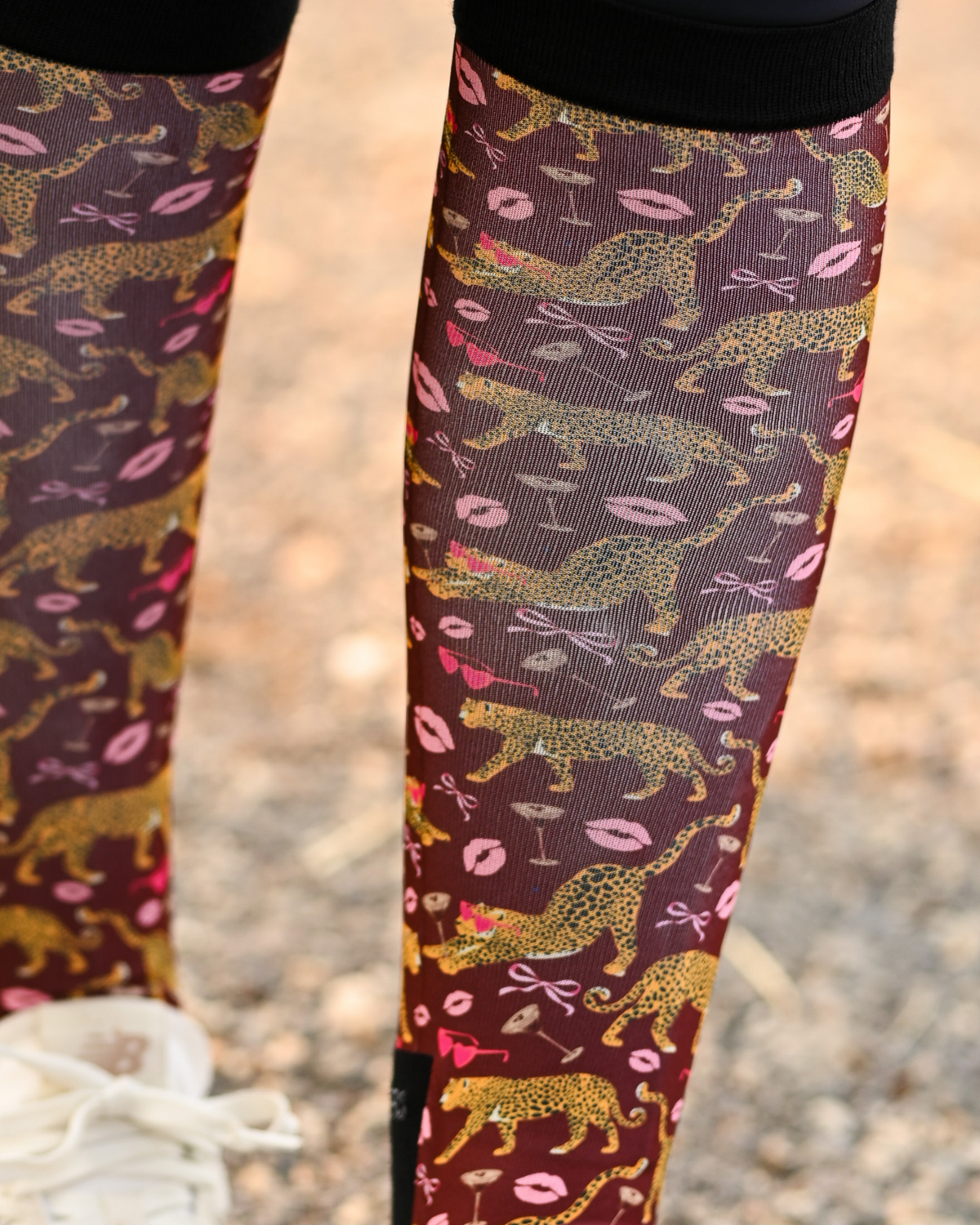 Close crop of the Ready to Play boot sock print, gold leopards, pink lips and bows on burgundy