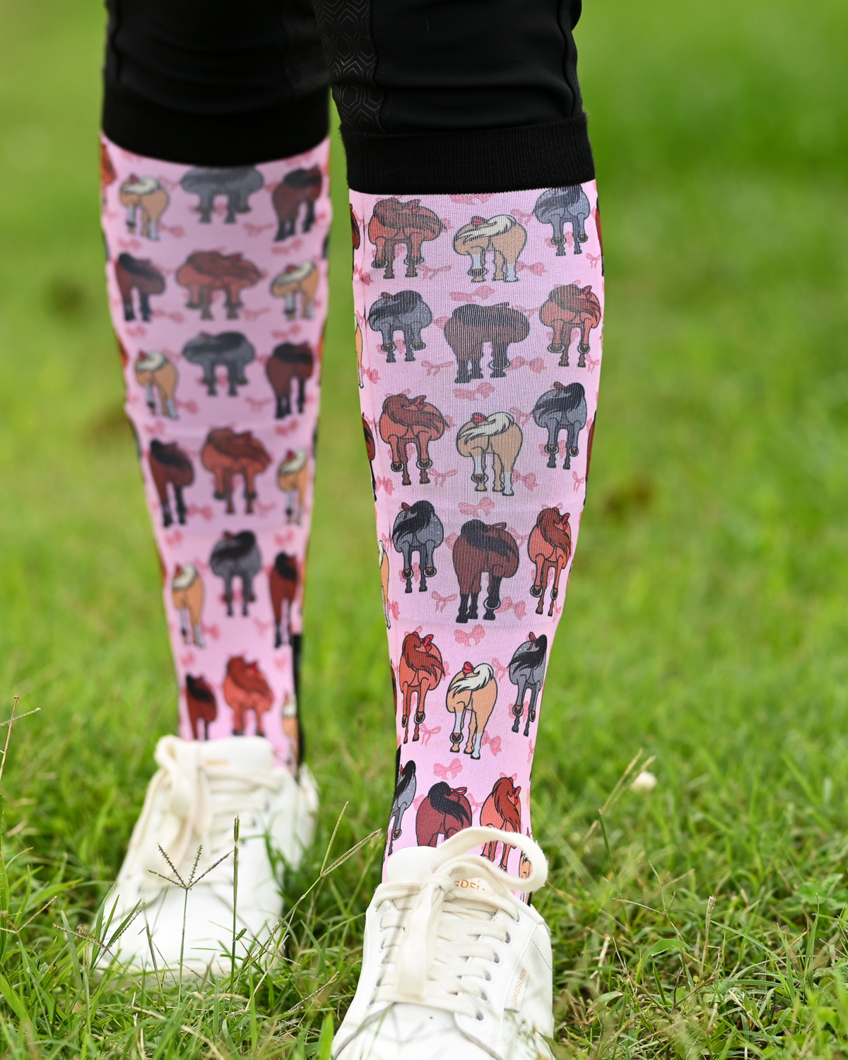 Red Ribbon Girlies riding boot socks styled over breeches, pink with horse hindquarters tied with red bows