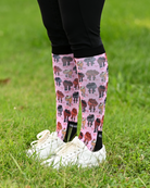 Red Ribbon Girlies equestrian boot socks worn at the barn, pink with horse hindquarters tied with red bows