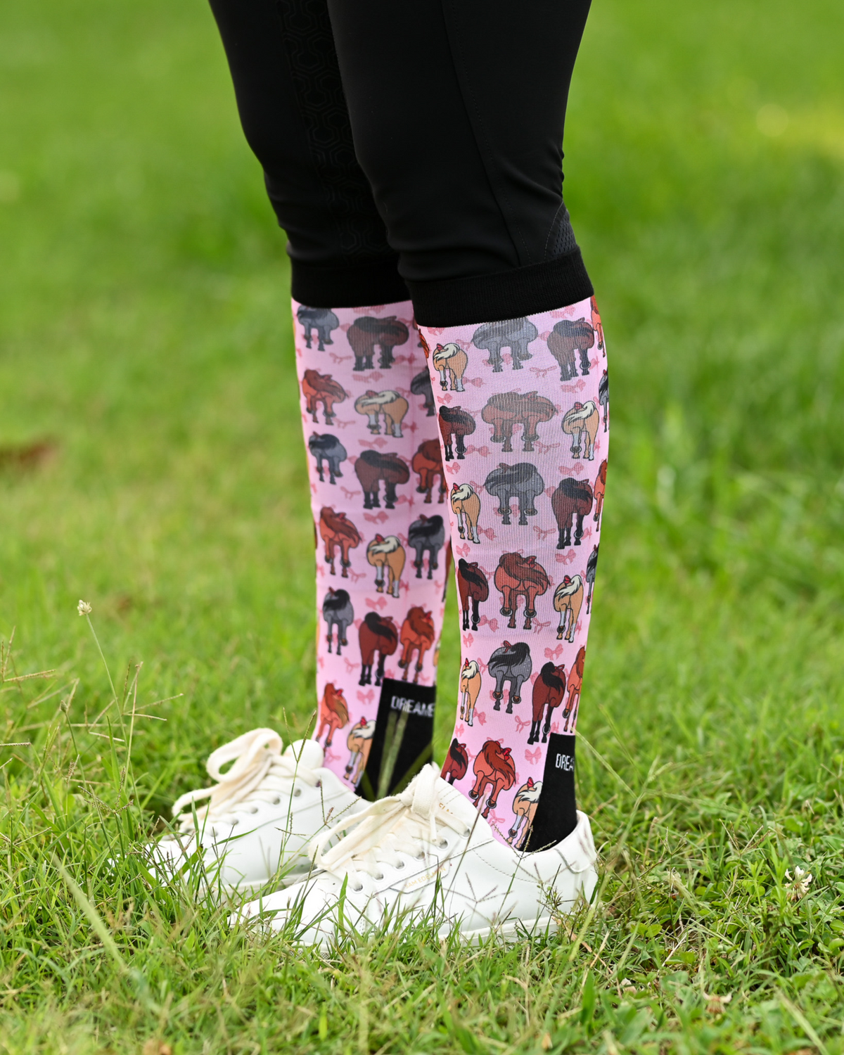 Red Ribbon Girlies equestrian boot socks worn at the barn, pink with horse hindquarters tied with red bows