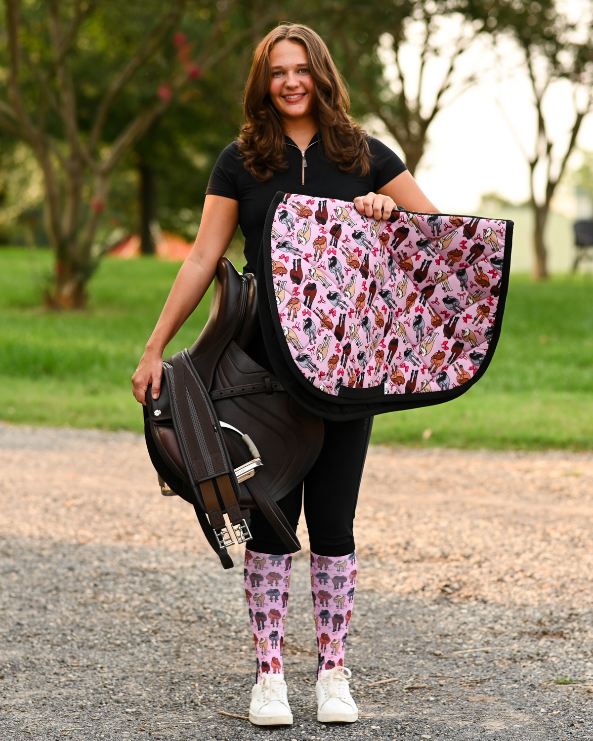 Red Ribbon Girlies saddle pad carried at the barn, pink quilting printed with horse hindquarters tied with red bows