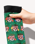 Hand holding the black cuff of the Be Brave boot sock, close-up of the pink tigers and Be Fierce lettering on green