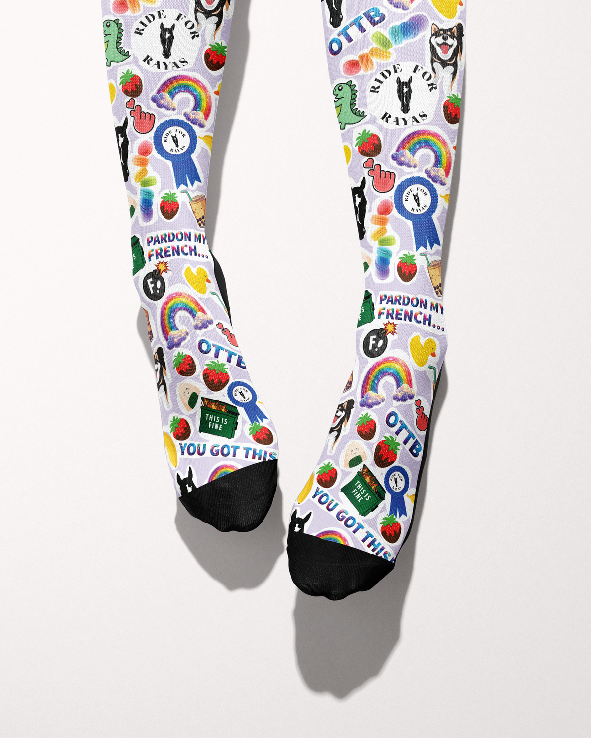 Friendship socks shown from the toes, black toe caps with blue ribbons, strawberries and Ride for Rayas logos
