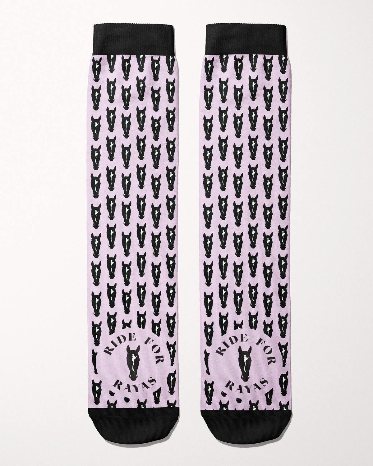 Ride for Rayas Nikko equestrian boot socks in pale pink with black horse heads, flat lay of the pair, by Dreamers & Schemers