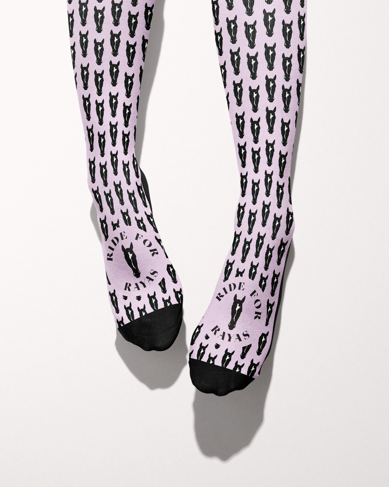 Nikko socks seen from the toes, black toe caps and the Ride for Rayas horse logo over the pink horse-head print