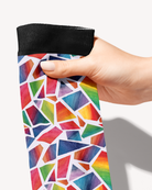 Original Art boot sock held by its black cuff, close-up of the hand-painted rainbow mosaic shapes on white