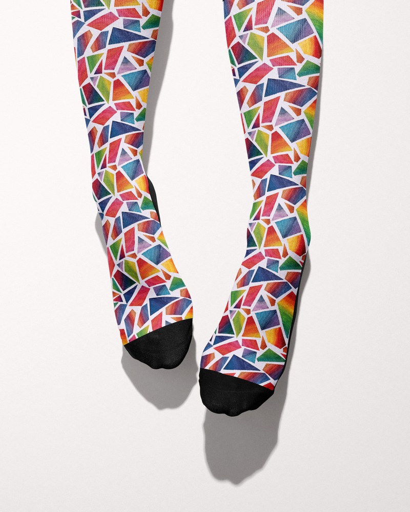 Original Art socks shown from the toes, black toe caps against the red, blue, green and yellow mosaic print
