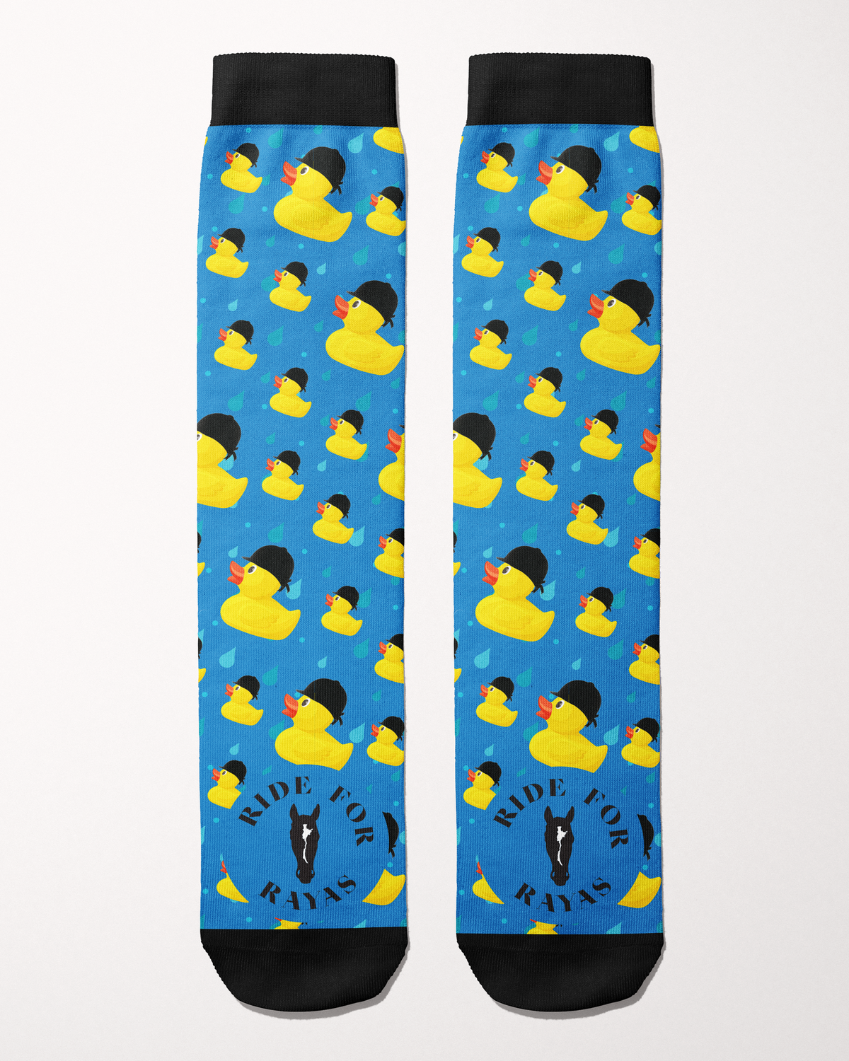 Ride for Rayas Rubber Ducky equestrian boot socks in bright blue with helmet-wearing ducks, flat lay, by Dreamers & Schemers
