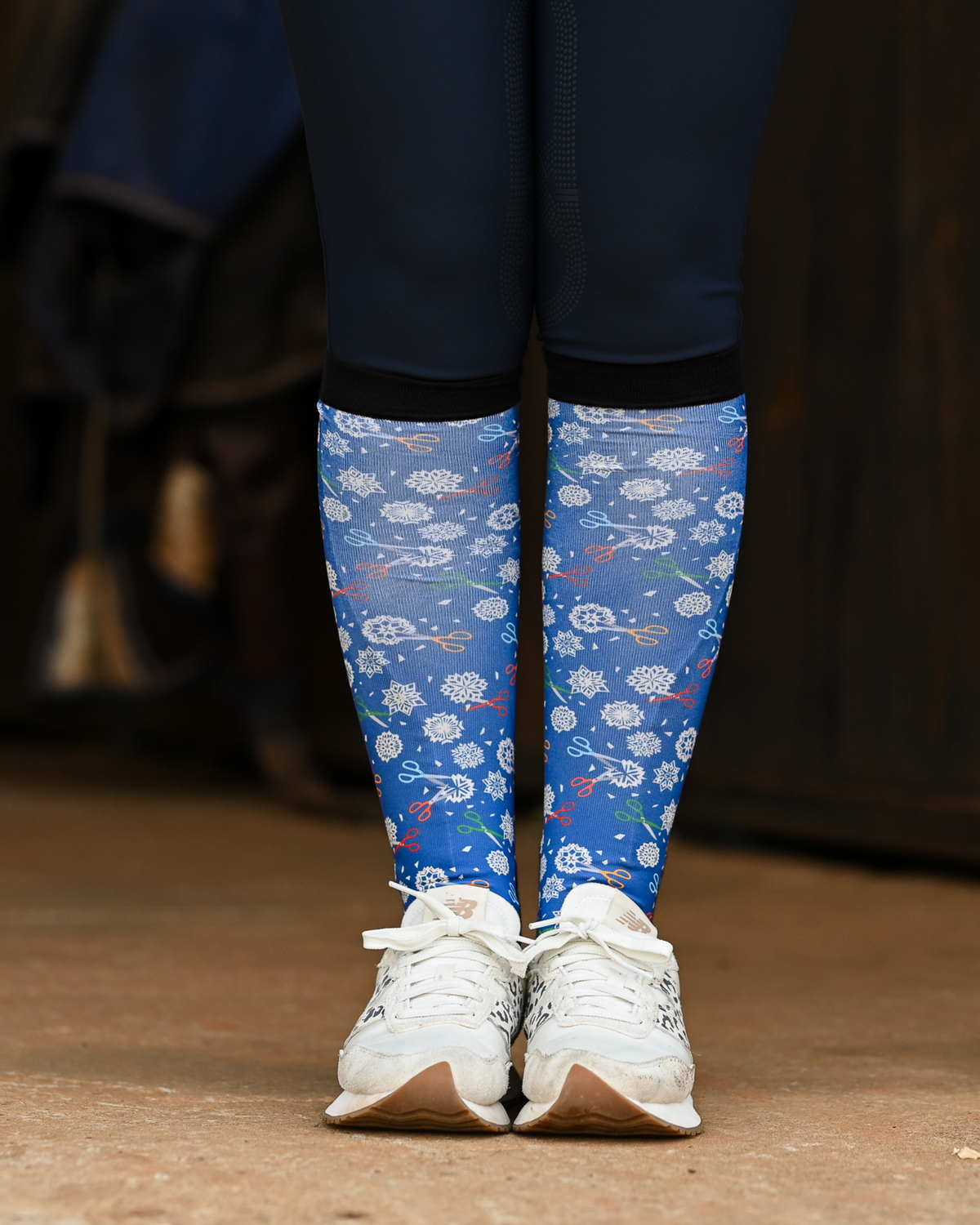 Shear Magic boot socks seen from the front, cobalt blue ground scattered with white clip rosettes and coloured scissors