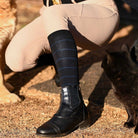Knit boot socks with blue stripes worn with black equestrian boots and beige riding pants