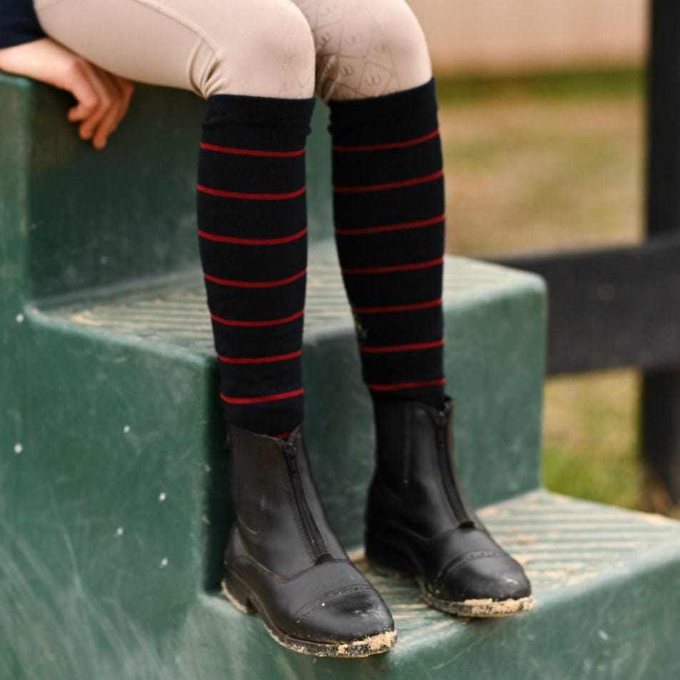 Black knit boot socks with red stripes worn with black riding boots