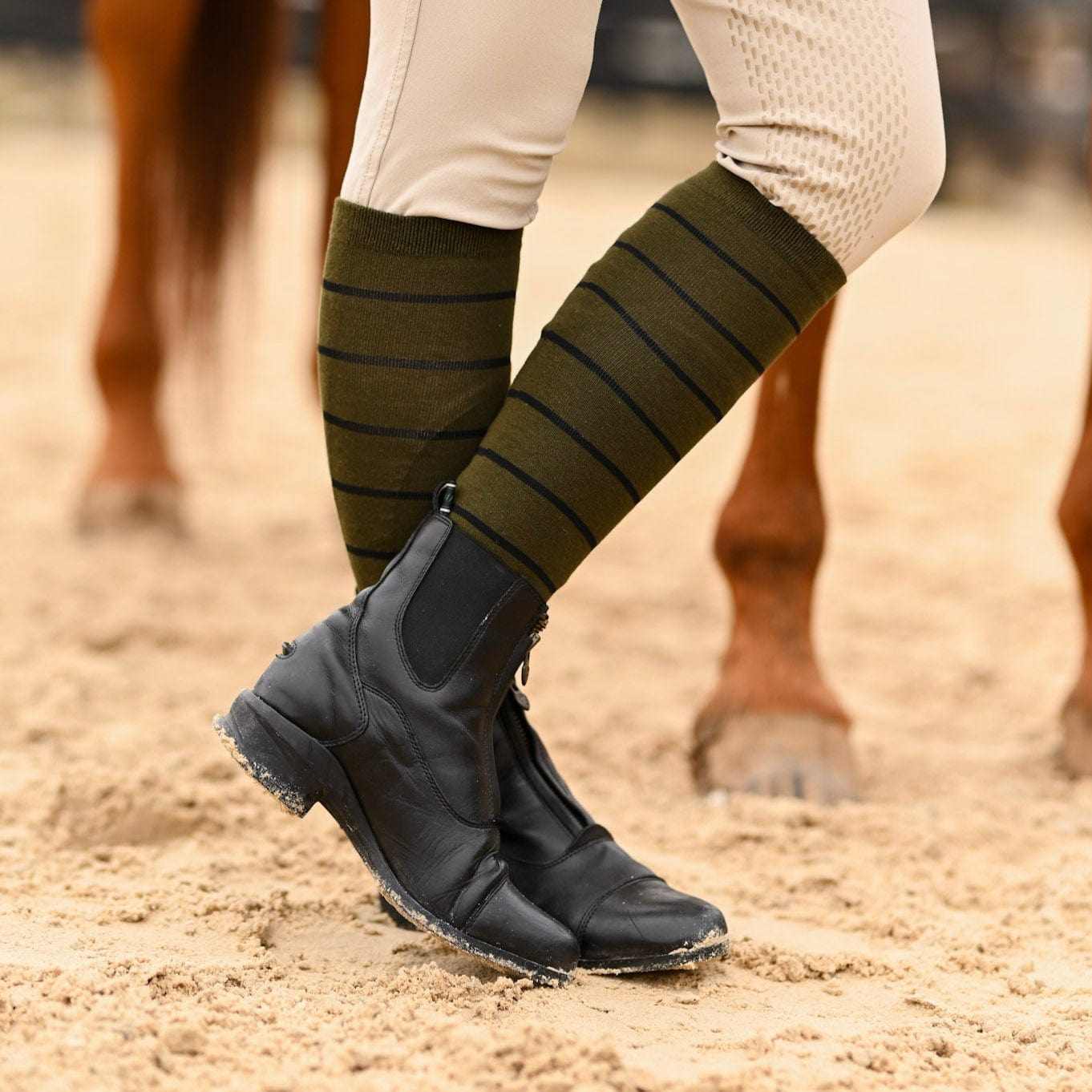 Knit boot socks with stripes worn with black riding boots and beige equestrian pants