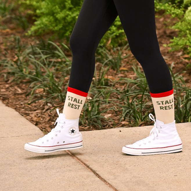 Person wearing Stall Rest Equestrian Bundle socks with white high-top sneakers and black leggings outdoors