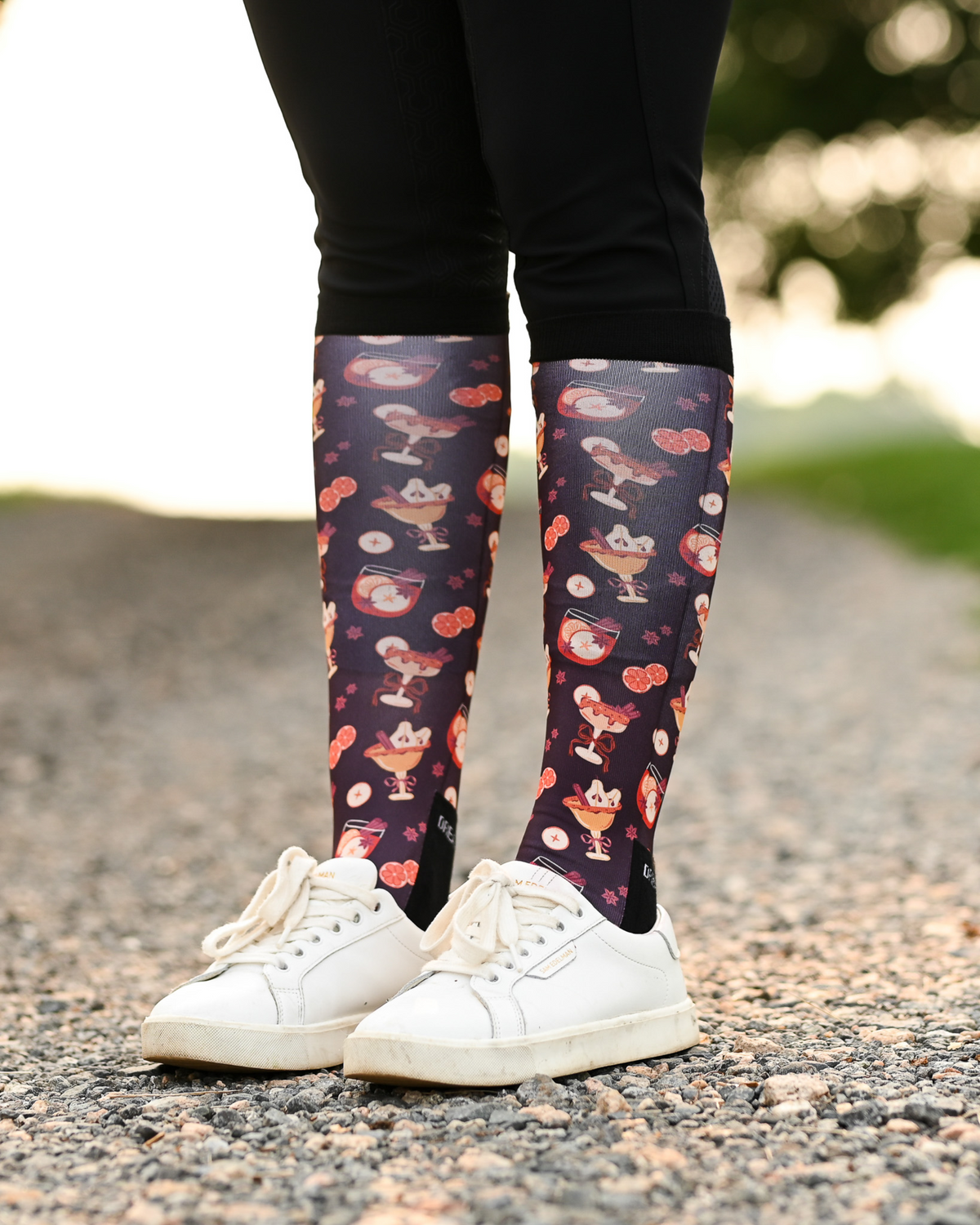 Stir Crazy equestrian boot socks worn at the barn, dark plum with cocktail glasses and citrus slices