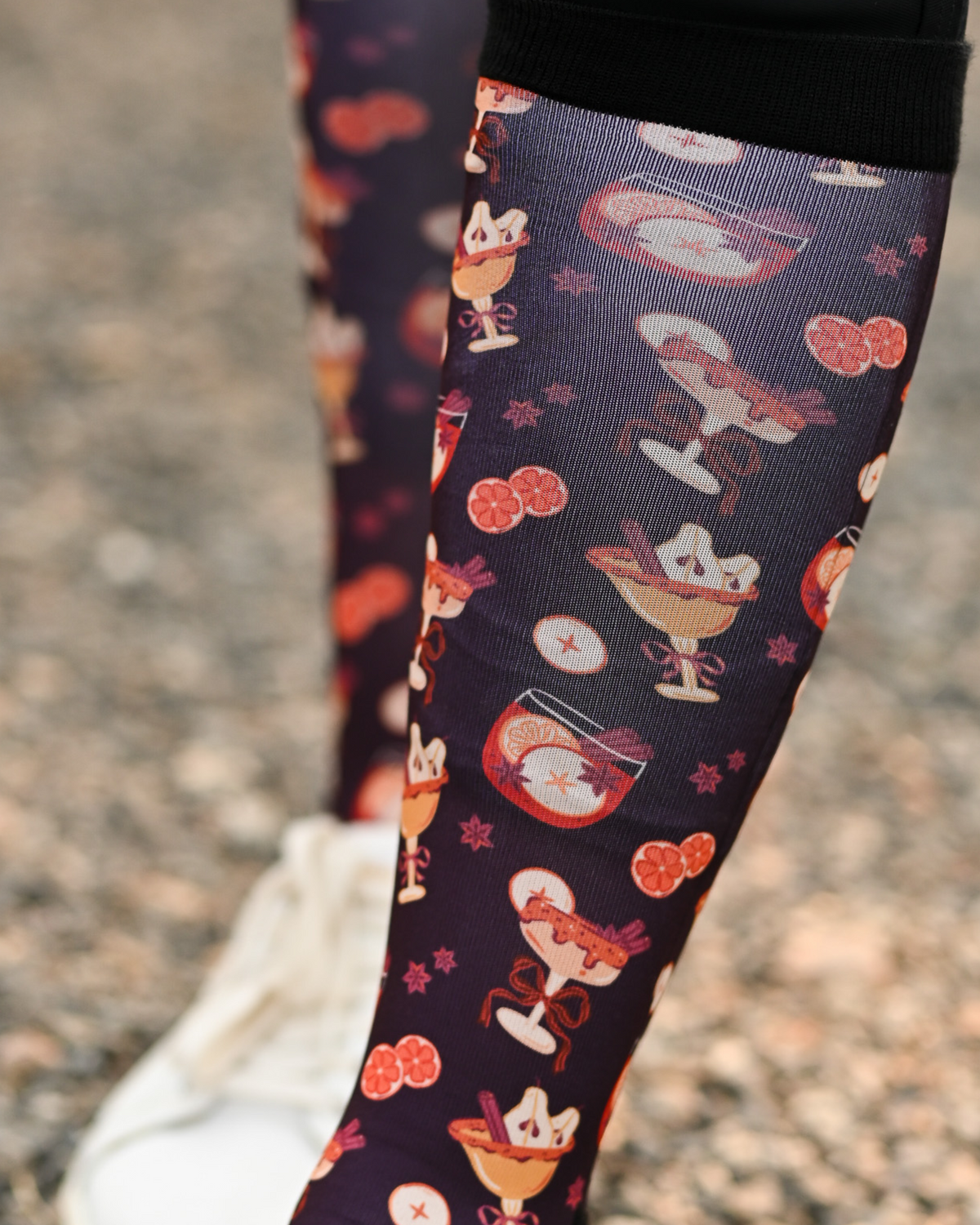Close crop of the Stir Crazy boot sock print, cocktail glasses and citrus slices on dark plum