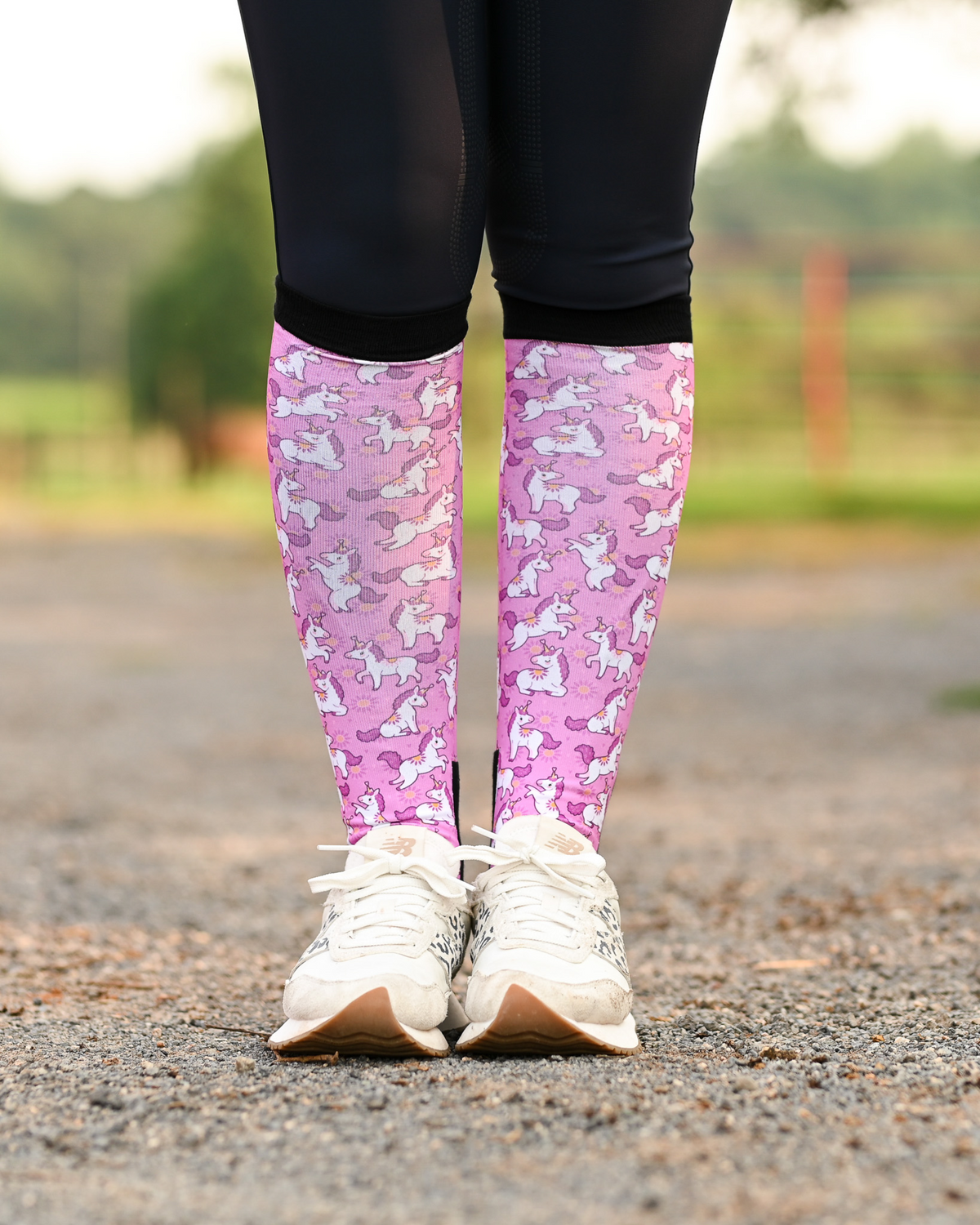 Sunshine and Unicorns riding boot socks styled over breeches, bright pink with white unicorns and yellow suns