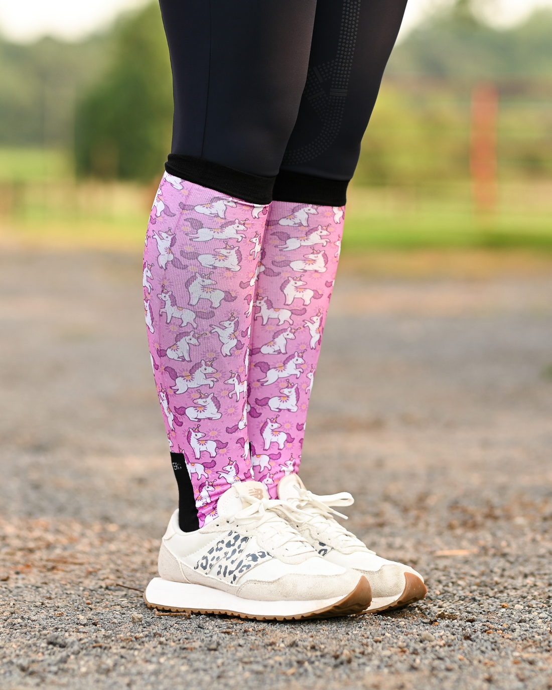 Sunshine and Unicorns equestrian boot socks worn at the barn, bright pink with white unicorns and yellow suns