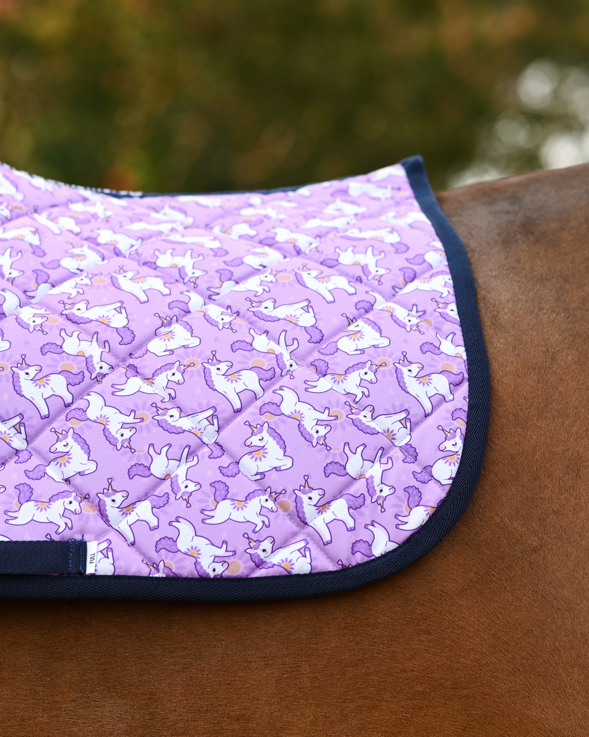 Close view of the Sunshine & Unicorns print: white unicorns and golden suns on lilac, navy edging