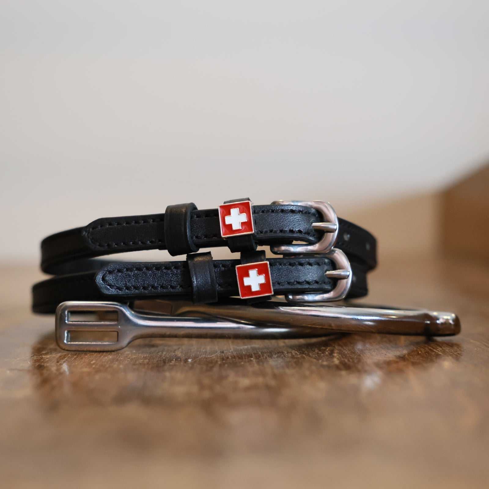Black leather spur straps with Switzerland flag charm and stainless steel buckle