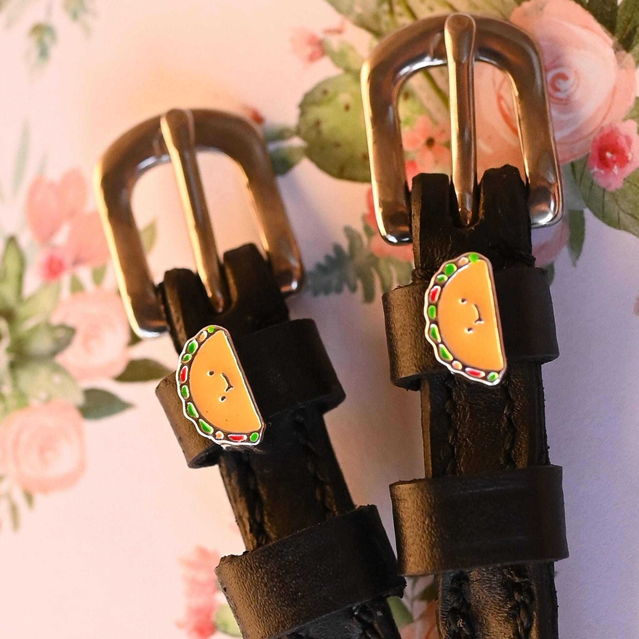 Black leather spur straps with stainless steel buckles and taco-shaped custom charms